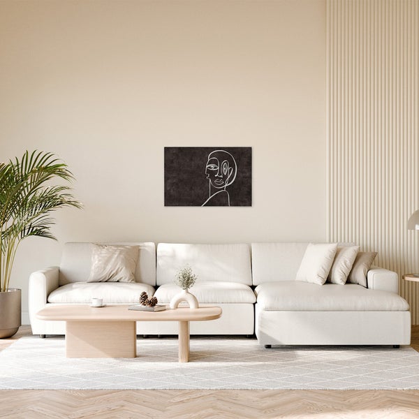 Dekoratives Leinwandbild mit abstrakter Darstellung eines Gesichtes in einem hellen Wohnzimmer.