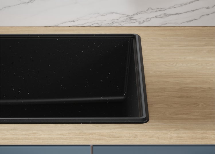 Schwarze Küchenspüle aus Verbundwerkstoff mit Glitzer in einer Arbeitsplatte.