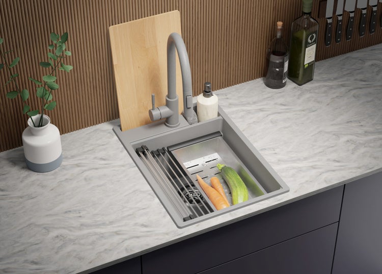 Küchenspüle mit Armatur, Schneidebrett und Gemüse auf einer Küchentheke.