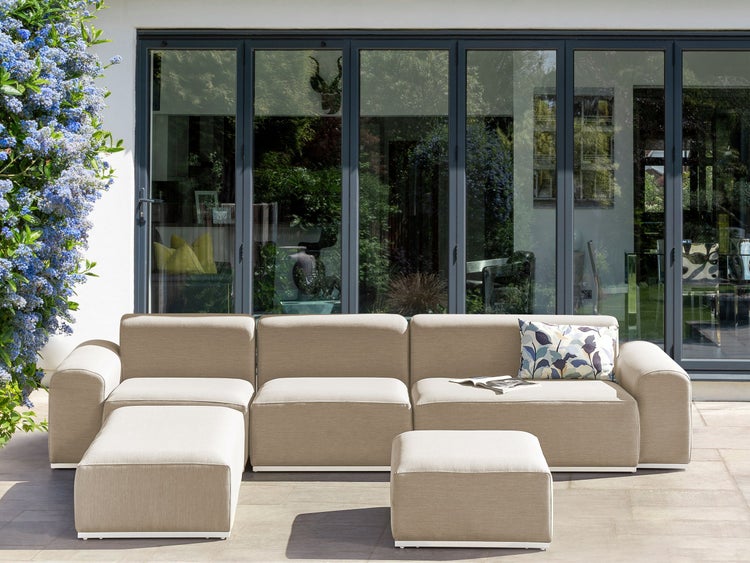 Gartenlounge-Set mit Sofas und Hockern auf einer Terrasse