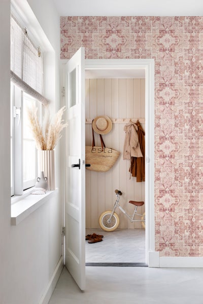 Eingangsbereich mit gemusterter Tapete, Dekoration und Kinderfahrrad