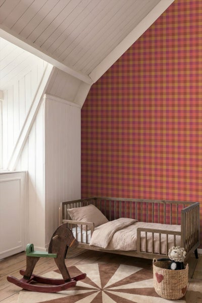 Vlies-Fototapete mit kariertem Muster im Kinderzimmer mit Kinderbett aus Holz und Schaukelpferd unter einer Dachschräge.
