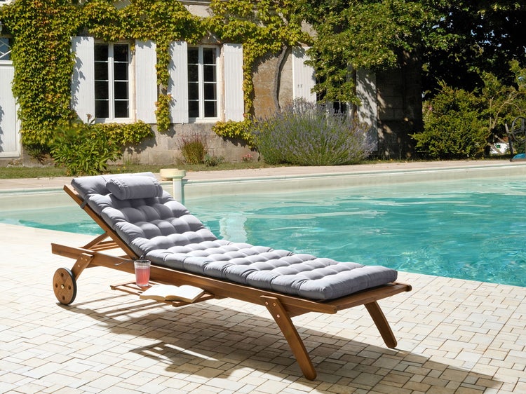 Holzliege mit grauer Auflage am Pool