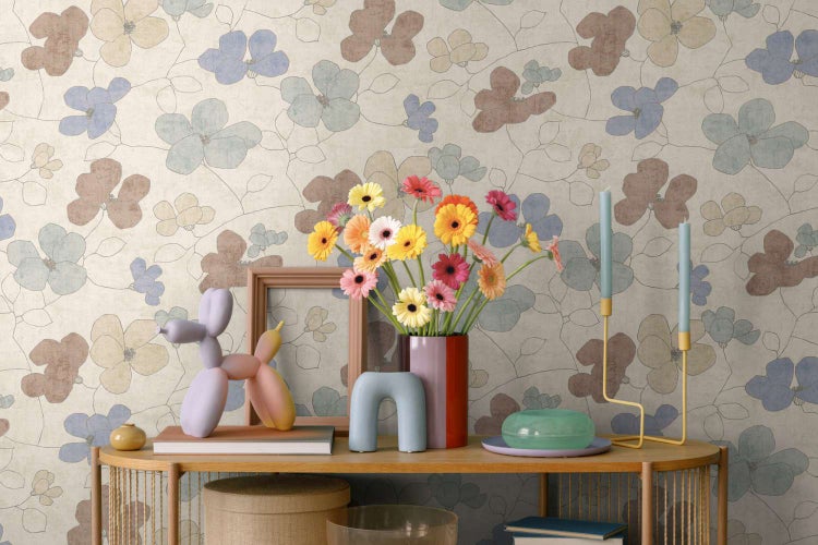 Wohnraum mit einer Tapete mit floralem Muster in Pastelltönen und einem hölzernen Konsolentisch mit dekorativen Gegenständen und frischen Blumen.