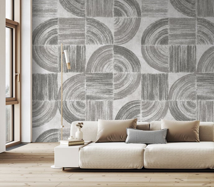 Wohnzimmer mit geometrischer Tapete, Sofa und Stehlampe.