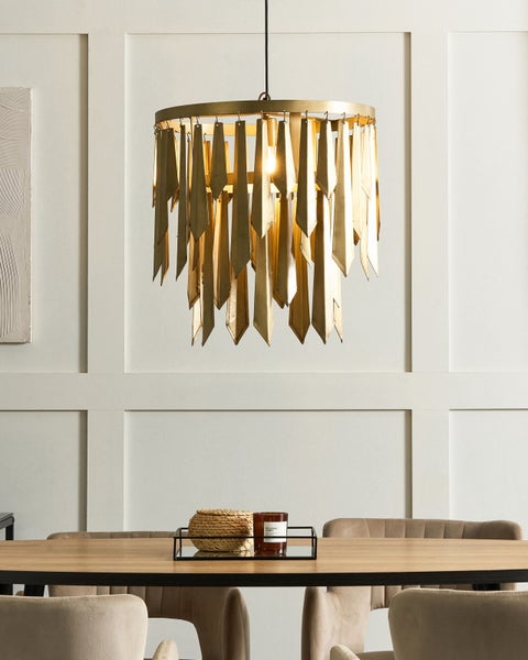 Szene mit einer goldenen Hängeleuchte über einem Esstisch.