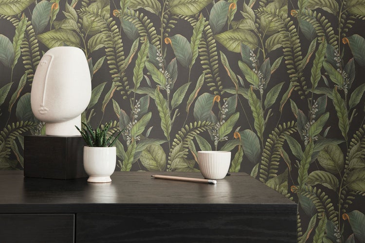 Wohnzimmer mit Dschungel-Tapete, Sofa, Kissen, Büchern und Lampe für eine gemütliche Atmosphäre.