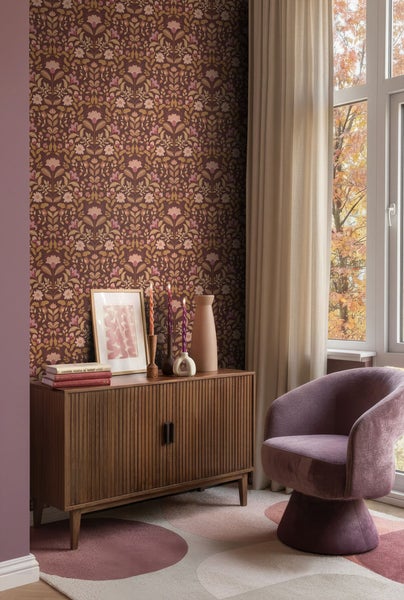 Einrichtungsbeispiel mit Kommode, Sessel, Teppich und floraler Tapete