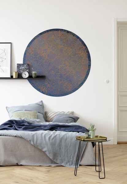 Wandgestaltung mit kreisförmigem Muster über einem Bett im Schlafzimmer.