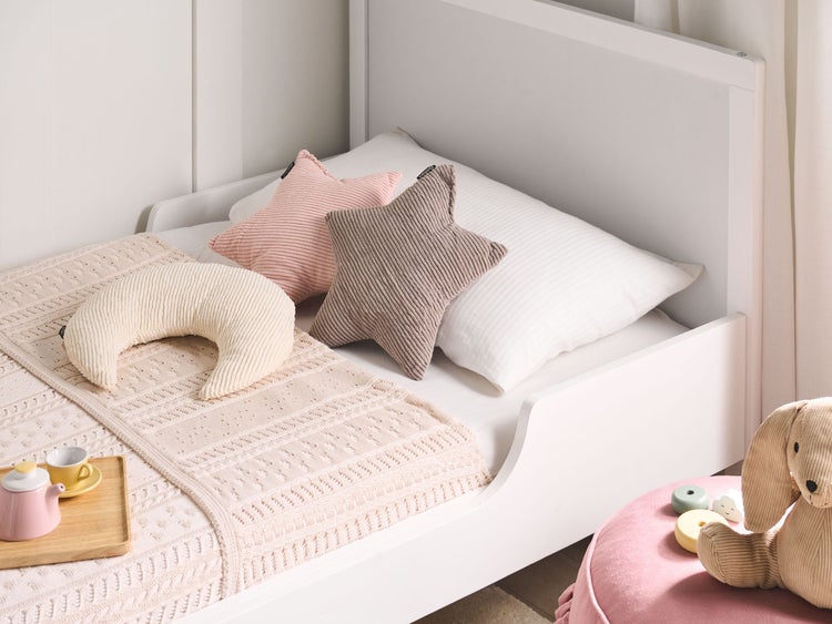 Kinderzimmer Szene mit weißem Bett, Sternkissen, Mondkissen und gehäkelter Decke