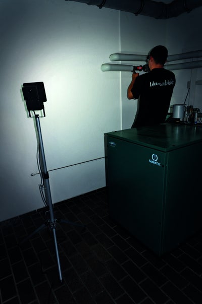 Szene mit montierenden Installateur und LED-Baustrahler auf Stativ