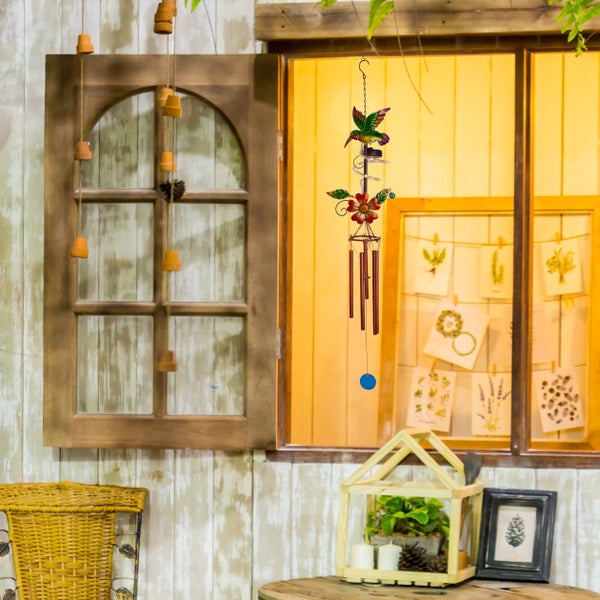 Dekorative Szene mit Fenster, Windspiel mit Kolibri und Pflanzen