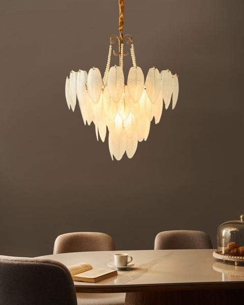 Federleuchter über einem Esstisch mit Geschirr und Stühlen