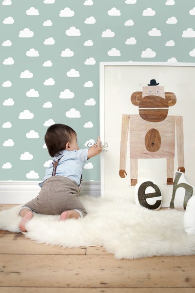 Kinderzimmer mit Wolken-Tapete und einem Kind, das auf einem Teppich vor einem Bild mit einem Affenmotiv spielt.