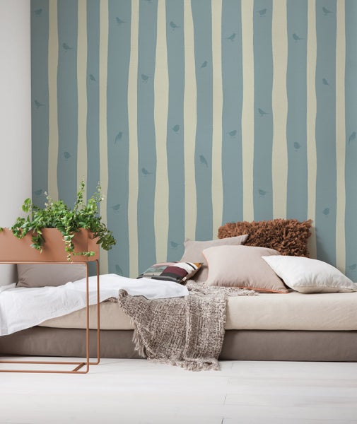 Dekoratives Zimmer mit gestreifter Tapete und Pflanzen auf einem Tisch
