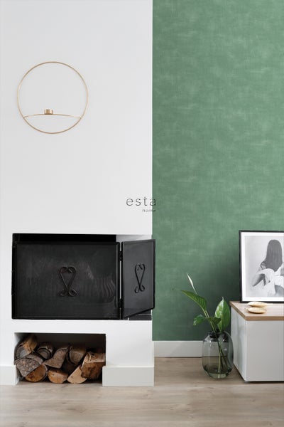 Wohnzimmer mit Kamin, Holzscheiten, Dekoration und Esta Home Logo