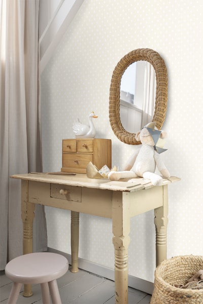 Baby liegt in einem Kinderbett mit Mobile und Betthimmel