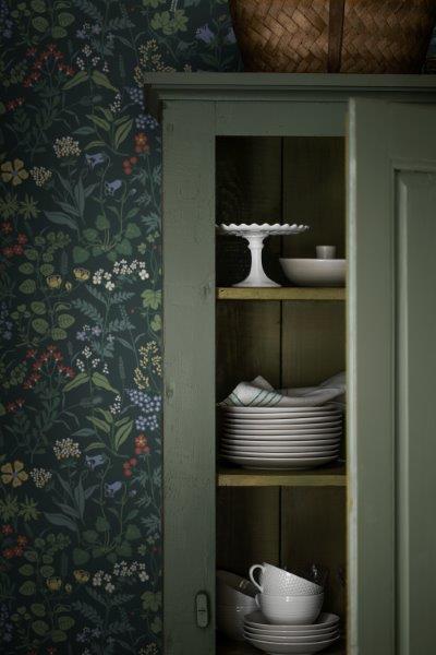 Vintage Küchenschrank mit Geschirr und floraler Tapete