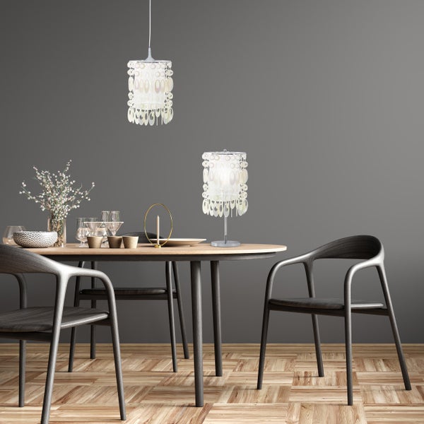 Esstisch mit Stühlen, Tischlampe und Pendelleuchte in einem hellen, freundlichen Ambiente