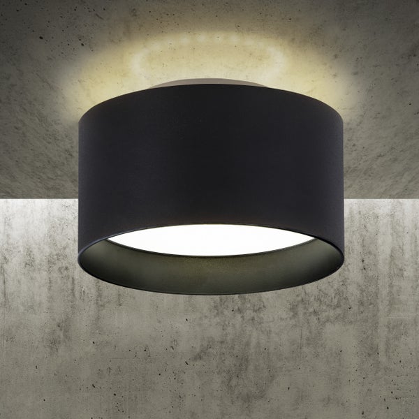 Schwarze Deckenleuchte mit zylindrischem Schirm an Betondecke