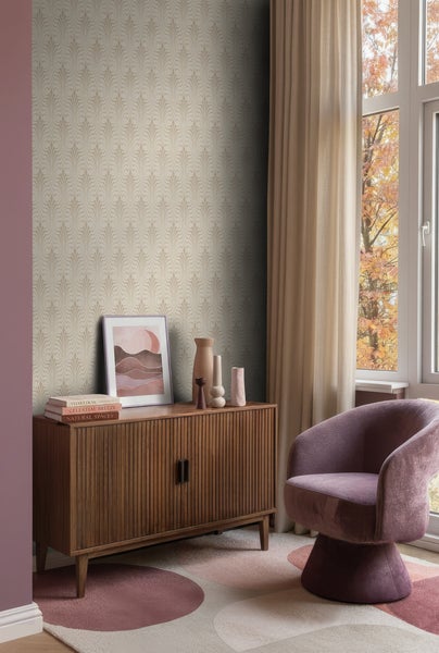 Vliestapete mit Art-déco-Muster in einem Wohnzimmer mit Sideboard aus Holz, Polstersessel und gemustertem Teppich.