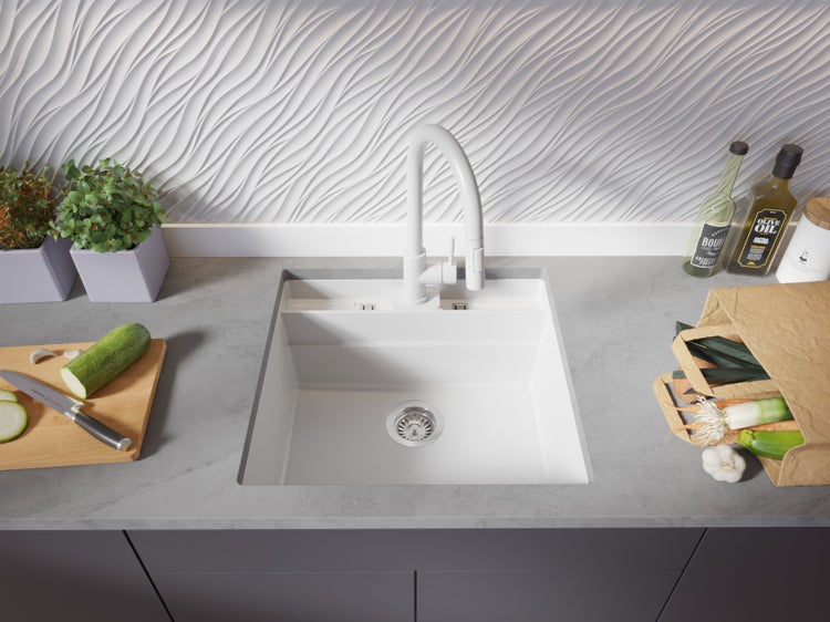 Küchenspüle mit Armatur, Schneidebrett und Lebensmitteln auf einer Küchentheke