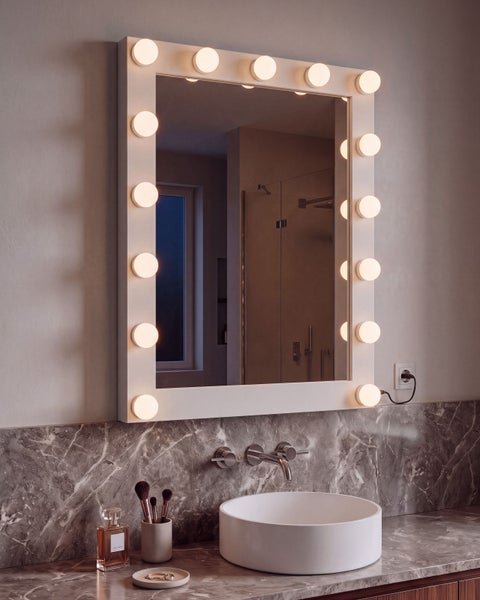 Wandspiegel mit integrierter LED Beleuchtung im Hollywood Stil über einem Aufsatzwaschbecken vor einer Fliesenwand in Marmoroptik.