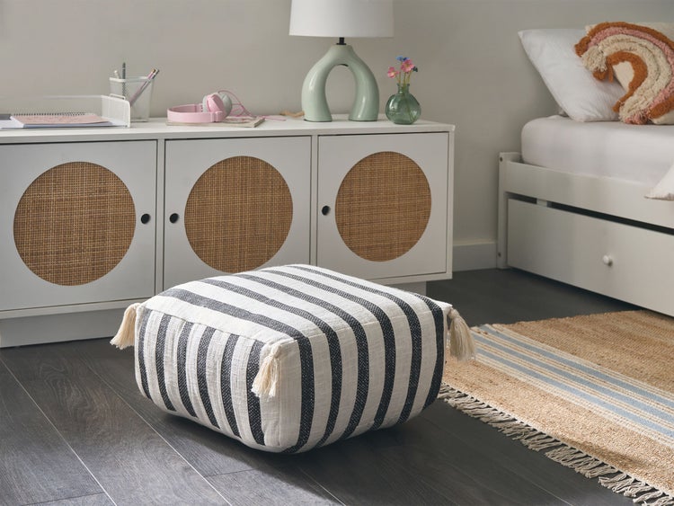 Einrichtungsidee für ein Kinderzimmer mit Schrank, Lampe, Bett und gestreiftem Sitzkissen