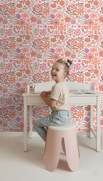 Retro-Blumentapete in einem hellen Kinderzimmer mit einem Kind an einem Schreibtisch.