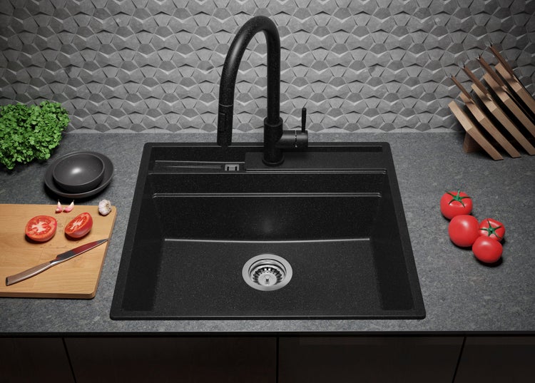 Schwarze Küchenspüle aus Granit mit Armatur und Lebensmitteln