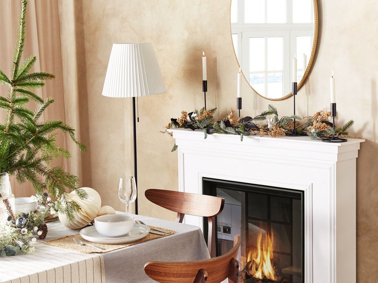 Festlich gedeckter Esstisch mit Kamin, Spiegel und Weihnachtsdekoration für eine gemütliche Raumatmosphäre
