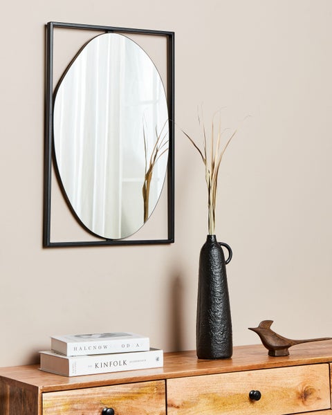 Detailaufnahme eines Spiegels mit schwarzem Rahmen