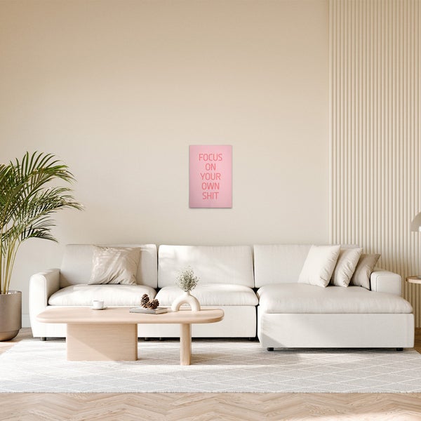 Wohnzimmer mit Couch, Tisch und pinkfarbenem Wandbild mit Text