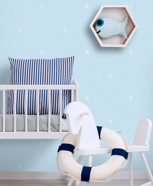 Kinderzimmer mit maritimer Dekoration: Babybett, Kissen, Spielzeugfisch und Rettungsring