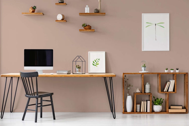 Modernes, organisiertes Arbeitszimmer mit einem Holzschreibtisch mit schwarzen Metallbeinen, einem schwarzen Holzstuhl und einem asymmetrischen Holzregal.