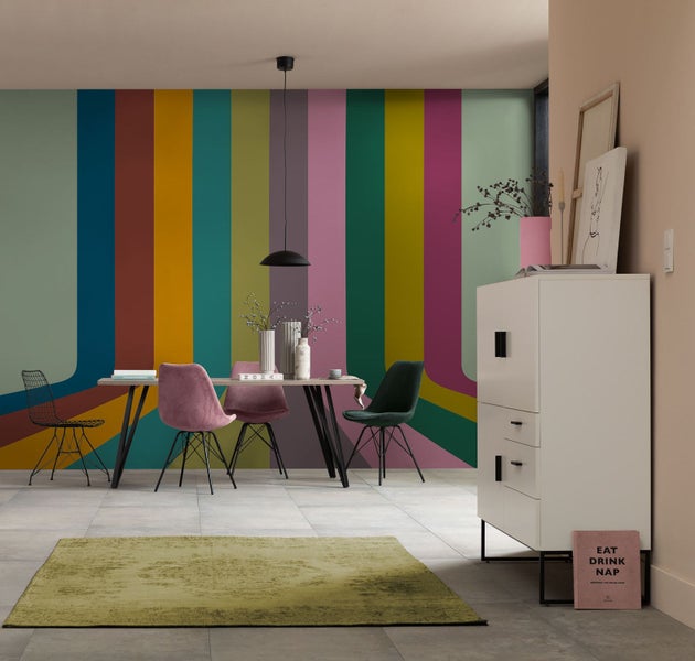 Esszimmer mit Esstisch, Stühlen, Sideboard und farbenfroher Wandgestaltung