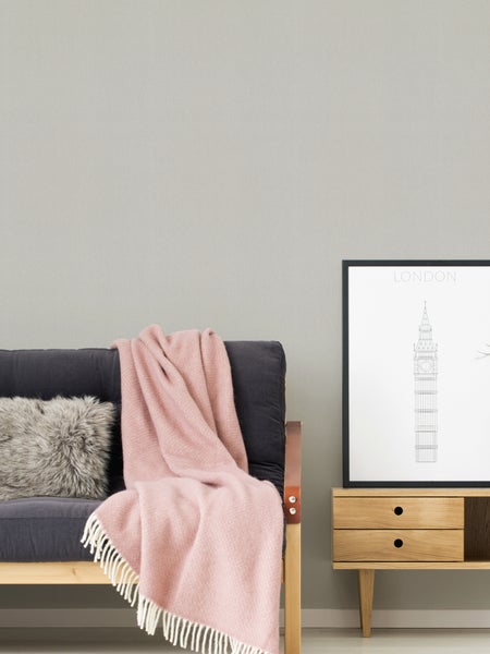 Wohnzimmer mit Sofa, Kissen, Decke, Kommode und London-Bild