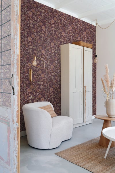 Schlafzimmer mit floraler Tapete, Bett und Nachttisch