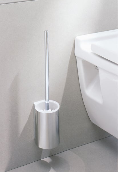 Wandmontierte WC Bürstengarnitur aus Metall mit glänzender Oberfläche in einem modernen Badezimmer neben einer weißen Toilette.