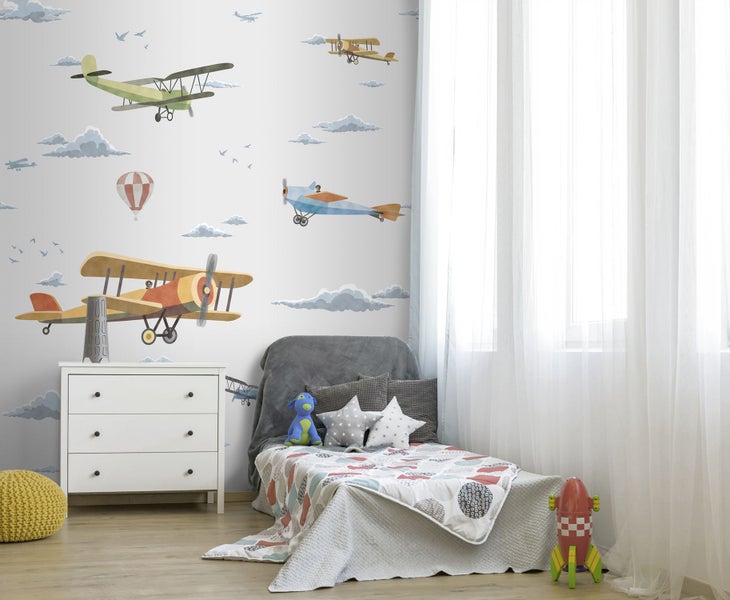 Kinderzimmer mit Flugzeugtapete, Kommode und Bett