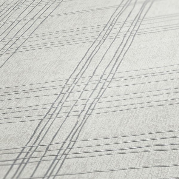 Innenraum mit Ziegelwand, Holzboden, dunklem Holztisch, weißen Stühlen und Tapete mit Karomuster.