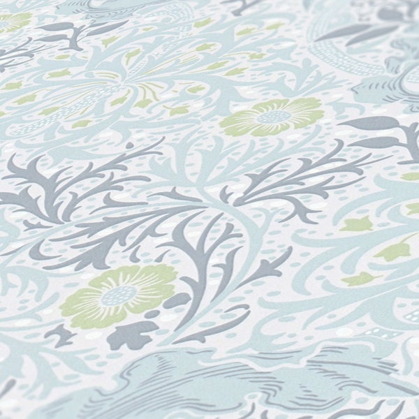 Dekorative Tapete mit floralem Muster hinter Kommode mit Topfpflanze und Uhr