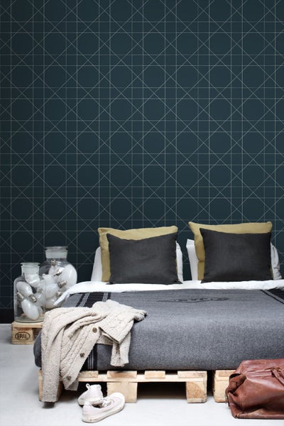 Schlafzimmer mit geometrischer Tapete und Palettenbett