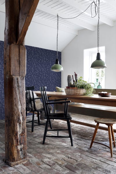 Essbereich mit Holztisch, Stühlen und dekorativer Wandtapete in einem hellen, geräumigen Zimmer.