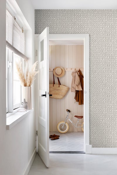 Heller Eingangsbereich mit Stricktapete, offener Tür und dekorativen Elementen.