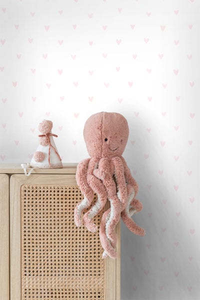 Dekoratives Kinderzimmer mit Stofftier-Oktopus und Herz-Tapete