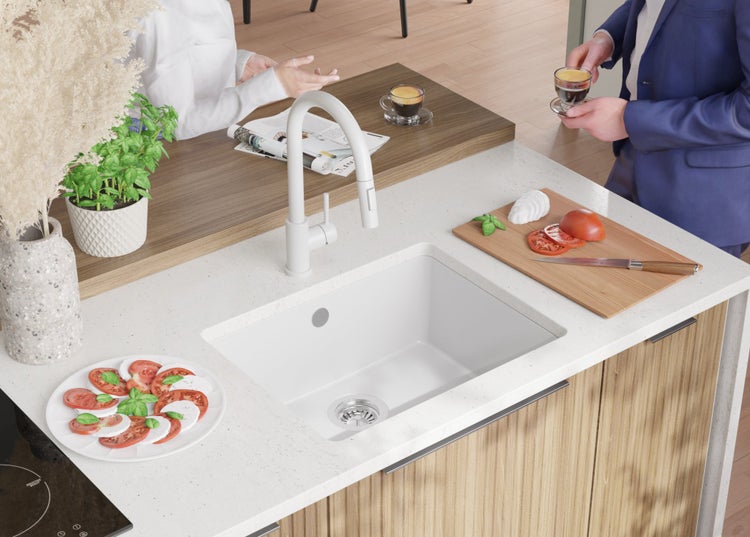 Küchenszene mit Spüle, Armatur, Arbeitsplatte und Zubereitung von Caprese