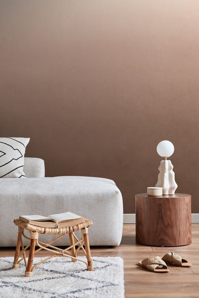 Wohnzimmerszene mit Sofa, Beistelltisch, Lampe, Hocker und Teppich für eine gemütliche Atmosphäre.