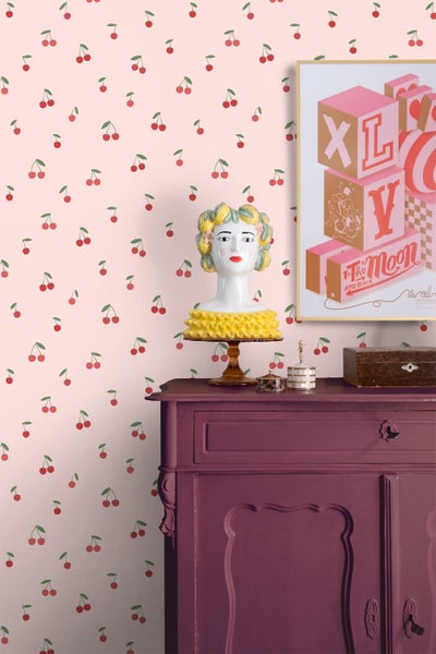 Dekoratives Zimmer mit Kirschtapete, bemalter Kommode und dekorativen Accessoires
