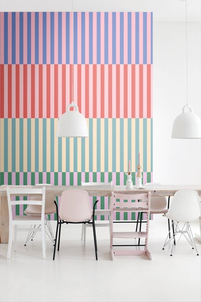 Ein Esszimmer mit einem Tisch und Stühlen vor einer gestreiften Tapete